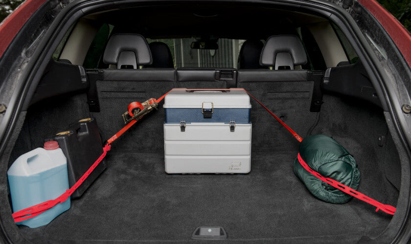 objects in a truck being tied down using tie downs